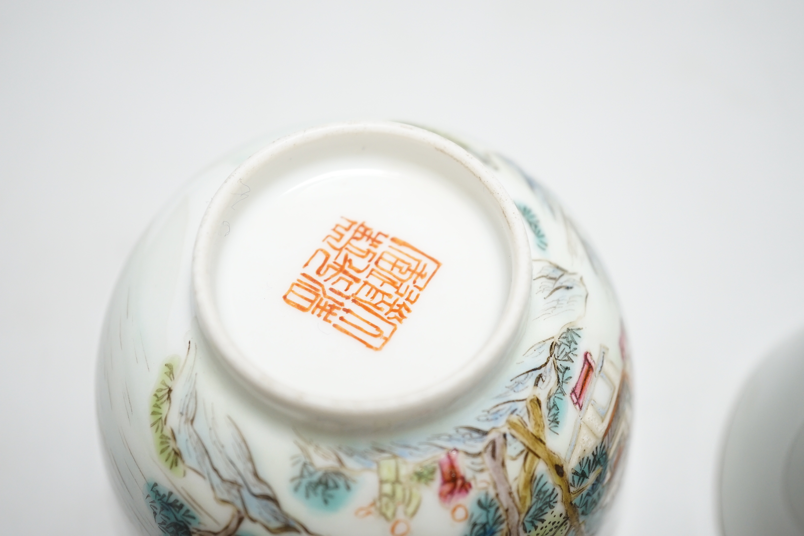 A pair of Chinese enamelled porcelain cups, landscapes and pagodas, 6cm tall